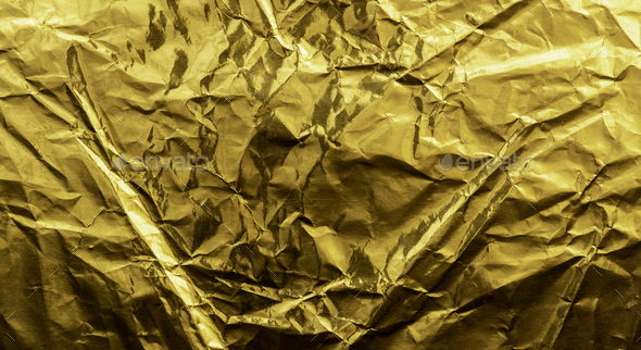 Crumpled gold foil paper texture. Wrinkled shiny metallic surface  background. Stock Photo