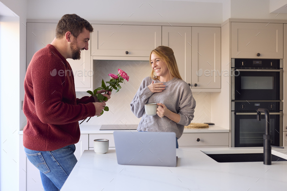 Romantic Couple In New Home With Man Giving Woman Bunch Of Flowers - Stock Photo - Images