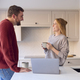 Couple At Home Looking At Laptop On Counter In Kitchen Together - PhotoDune Item for Sale