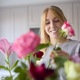 Woman Arranging Bunch Of Flowers On Kitchen Counter In New Home - PhotoDune Item for Sale