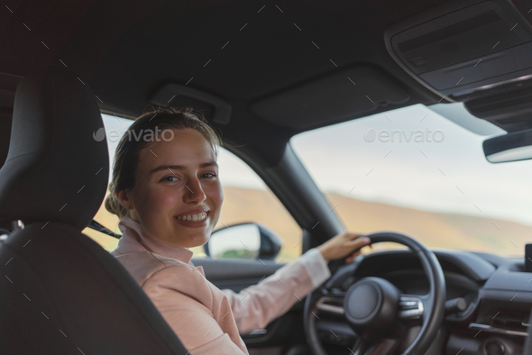 Rear view of young woman driving her electric car. - Stock Photo - Images