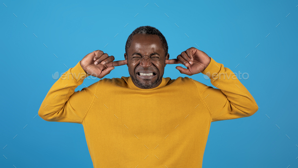 African american mature man plugging ears with fingers - Stock Photo - Images