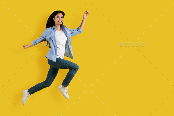 Satisfied excited cute young asian lady student in casual enjoy freedom, jumping and freezing in air - Stock Photo - Images