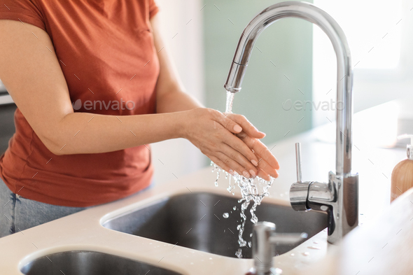Closeup Shot Of Young Woman Washing Hands In Kitchen Sink - Stock Photo - Images