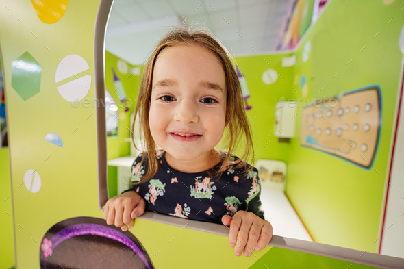 Close up portrait of girl playing at indoor play center playground. - Stock Photo - Images