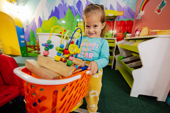 Baby girl playing at indoor kids kitchen playground. - Stock Photo - Images