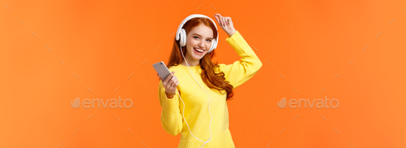 Lets dance. Cheerful carefree modern hipster girl with red curly hair and freckles, dancing lift