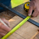Close-up of handyman measuring a board, outside in garden. - PhotoDune Item for Sale