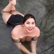 Full figured model in black swimming costume lying in geothermal water in outdoor pool at spa - PhotoDune Item for Sale