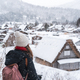 Young woman traveler looking at the beautiful UNESCO heritage village in the snow in winter - PhotoDune Item for Sale