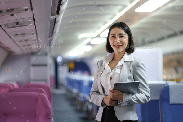 Attractive caucasian female passenger of airplane sitting in comfortable seat while working at - Stock Photo - Images