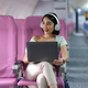 Asian young woman wearing headphone using laptop sitting near windows at first class on airplane - PhotoDune Item for Sale