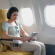 Young female listening favourite songs during flight in first class cabin using mobile playlist and - PhotoDune Item for Sale