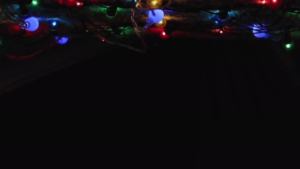 At the Top There are Fabulous Colored Christmas Lights on a Black Background alt