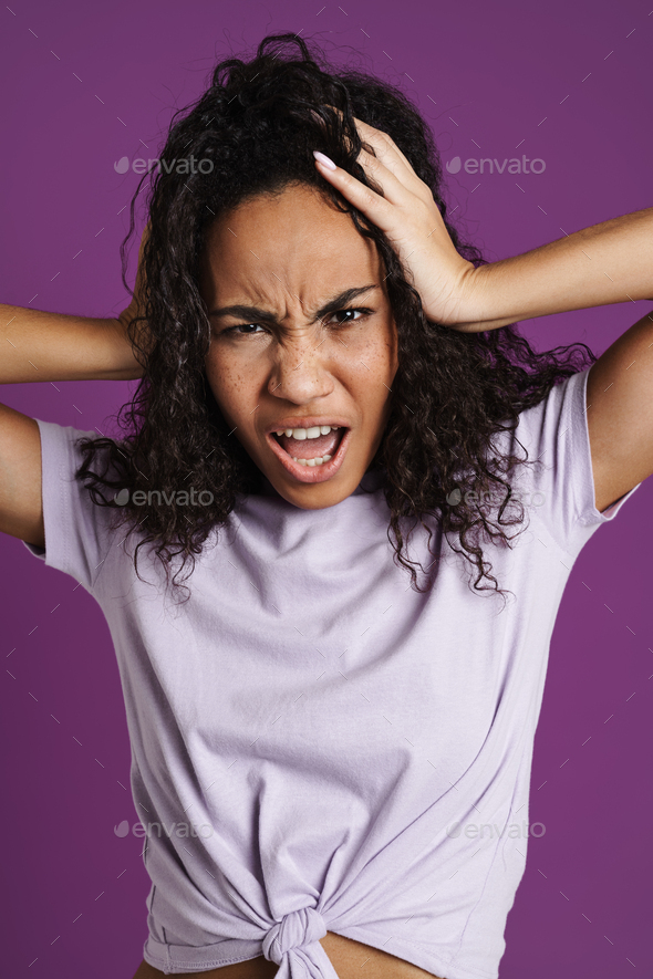 Furious Black Woman With Wavy Hair Screaming While Holding Her Head