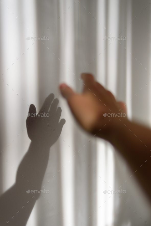 Person hand with its shadow on wall - Stock Photo - Images