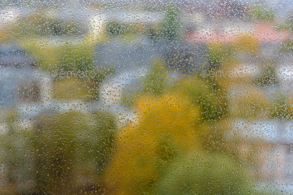 View to town through window glass with rain drops - Stock Photo - Images