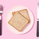 Flat lay of Whole wheat sandwich bread on plate, fork and knife on pink background - PhotoDune Item for Sale