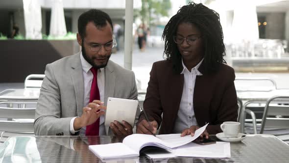 Successful Lawyers Talking While Sitting at Table with Documents alt