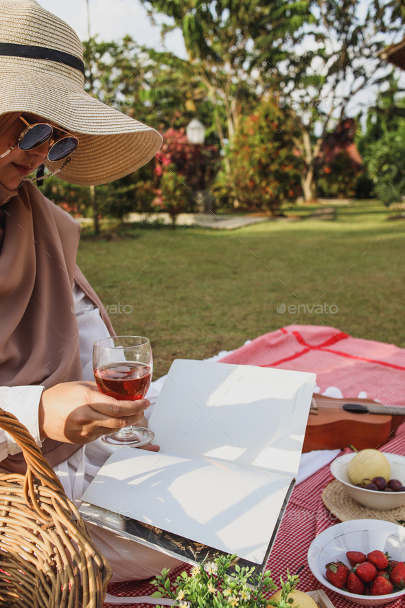 Woman reading a book on aesthetic picnic outdoors