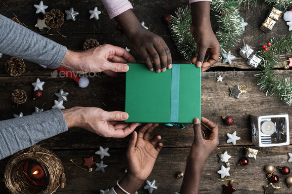 Caucasian father and his black coloured daughters holding christmas holiday gift box - Stock Photo - Images