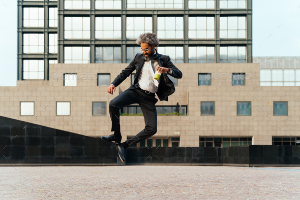 Young entrepreneur jumping and dancing to celebrate his successful day - Stock Photo - Images
