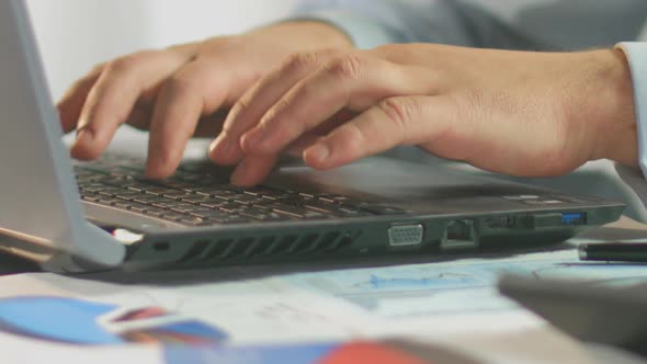 Businessman Typing Weekly Report on Laptop Computer, Close-Up of Male Hands alt