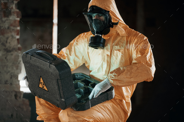 Man dressed in chemical protection suit in the ruins of the post apocalyptic building - Stock Photo - Images