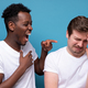 African man laughs at his friend. He won the argument or competition. - PhotoDune Item for Sale