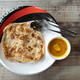 Overhead view of simple no frills roti canai with dhal curry on wooden table - PhotoDune Item for Sale
