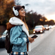 Young happy woman with headphones crossing the street. - PhotoDune Item for Sale