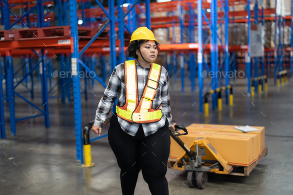 Overweight fat woman in warehouse pull hand pallet truck lift box to place in storage location