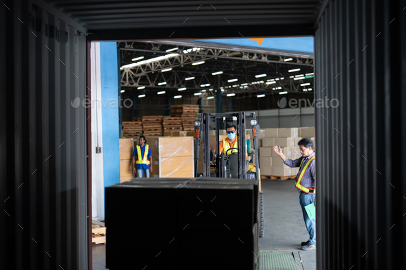 Forklift truck in warehouse drive in and out steel 40 feet steel container pick up goods boxes