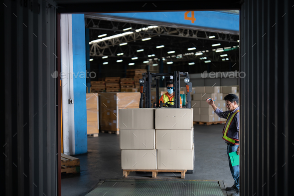 Forklift truck in warehouse drive in and out steel 40 feet steel container pick up goods boxes