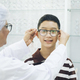 Smart young boy trying out new eyeglasses. - PhotoDune Item for Sale