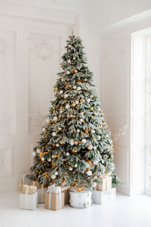 beautifully decorated room with a Christmas tree with gifts underneath ...