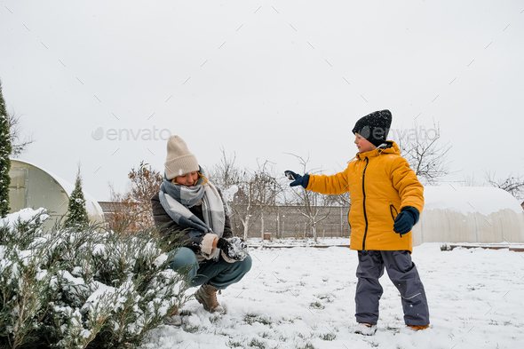 Winter games. Family playing snowballs in the courtyard of the house. winter, game, snow, christmas  - Stock Photo - Images