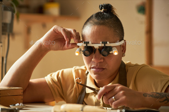 Female jeweler holding handmade ring in studio - Stock Photo - Images
