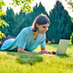 Teenage male lying on the grass using a laptop - PhotoDune Item for Sale