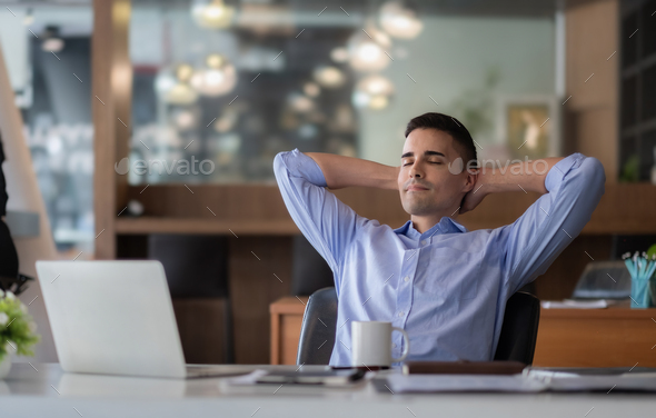Relaxed calm caucasian businessman resting sit at office desk after working for financial with