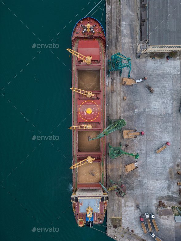 Aerial view of big cargo ship bulk carrier is loaded with grain of wheat in port - Stock Photo - Images