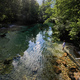 Top view of boy stand in emerald green water of the river Sava Bohinjka  - PhotoDune Item for Sale