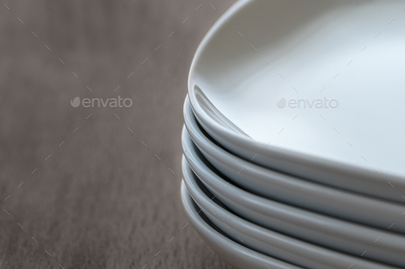 Stack pile of rectangular white ceramic dishes with rounded edges. .