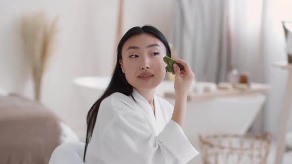 Domestic Face Sculpting Young Beautiful Asian Woman Making Skin Lifting Massage with Green Gouache alt