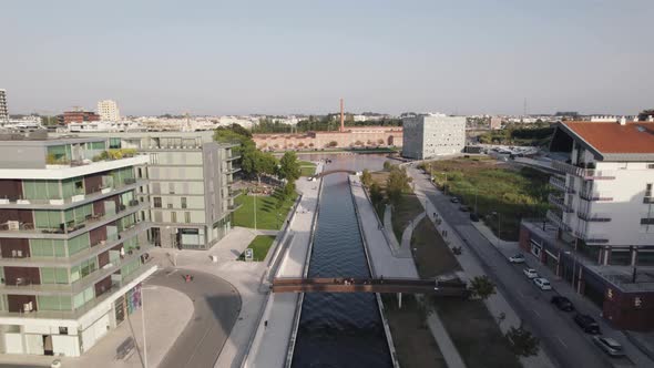 Establishing aerial dolly in shot above narrow water canal toward Aveiro Congress Center, Portugal. alt