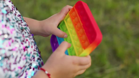 Child Girl Playing Colorful Squishy Silicone Bubbles Sensory Toy Simple Dimple Pop It Game Closeup alt