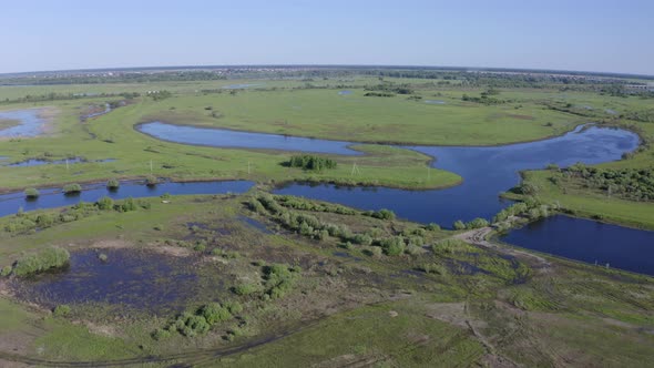 Scenic Aerial View of a River and Green Fields in a Countryside