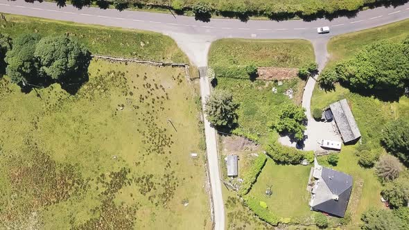 Drone flying over house and asphalt road. Lonely car driving in road. alt