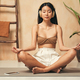 Asian woman in headphones meditating, sitting in yoga lotus pose, using meditation app on phone - PhotoDune Item for Sale