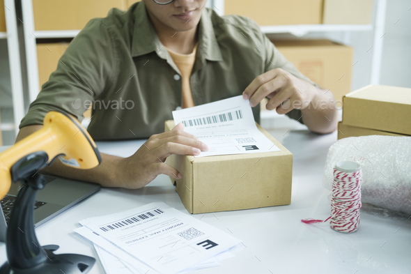 Young entrepreneur packing online order product for shipping. - Stock Photo - Images